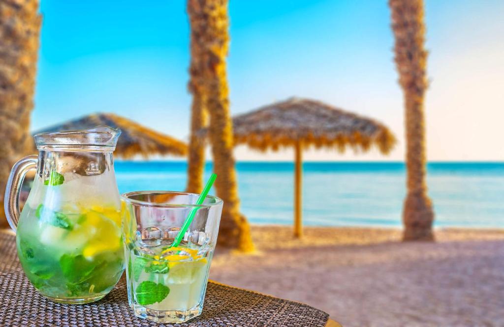 埃拉特瑞奇豪华套房酒店的海滩上的一杯杯装饮料