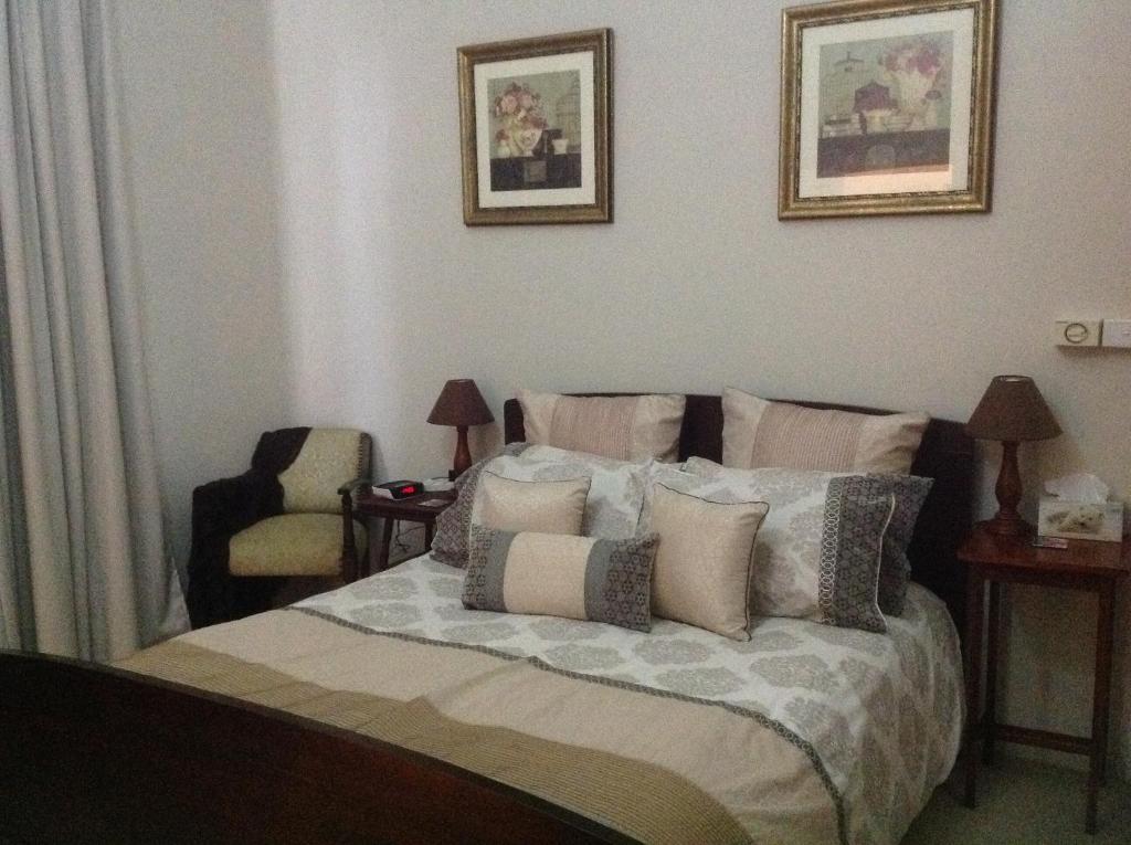 吉尔甘德拉Chinnock B&B的一间卧室配有带枕头和椅子的床