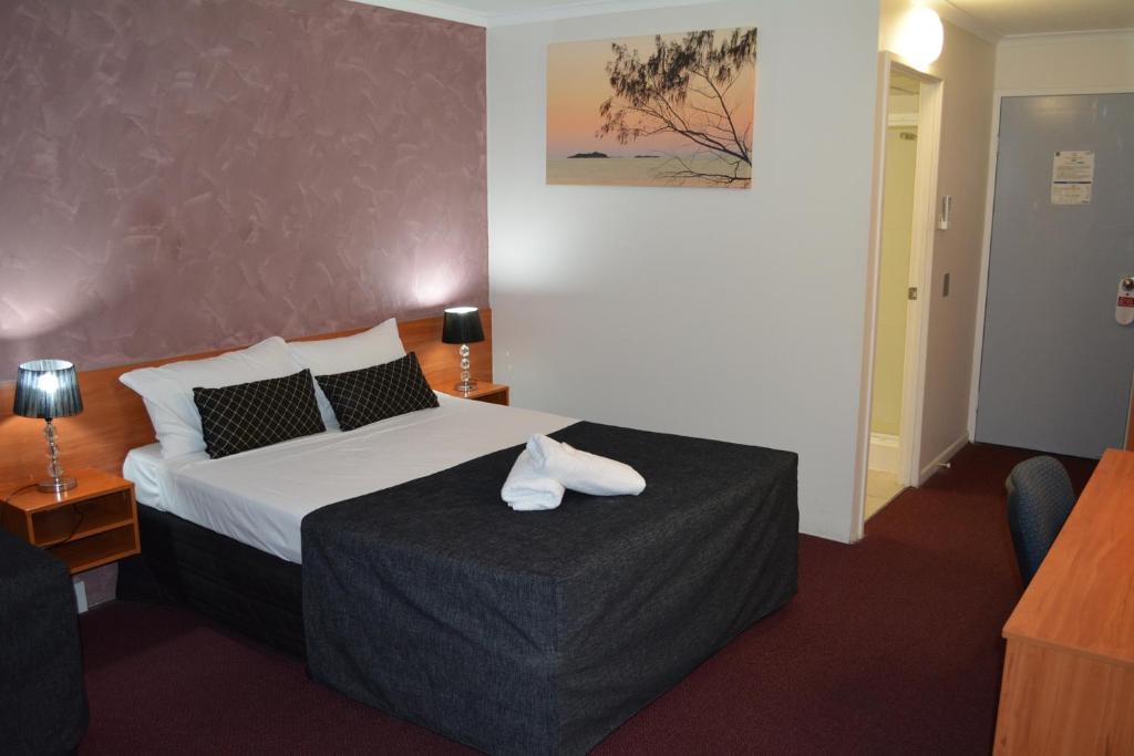 洛坎普顿汉普顿别墅汽车旅馆的一间酒店客房,配有一张带毛巾的床