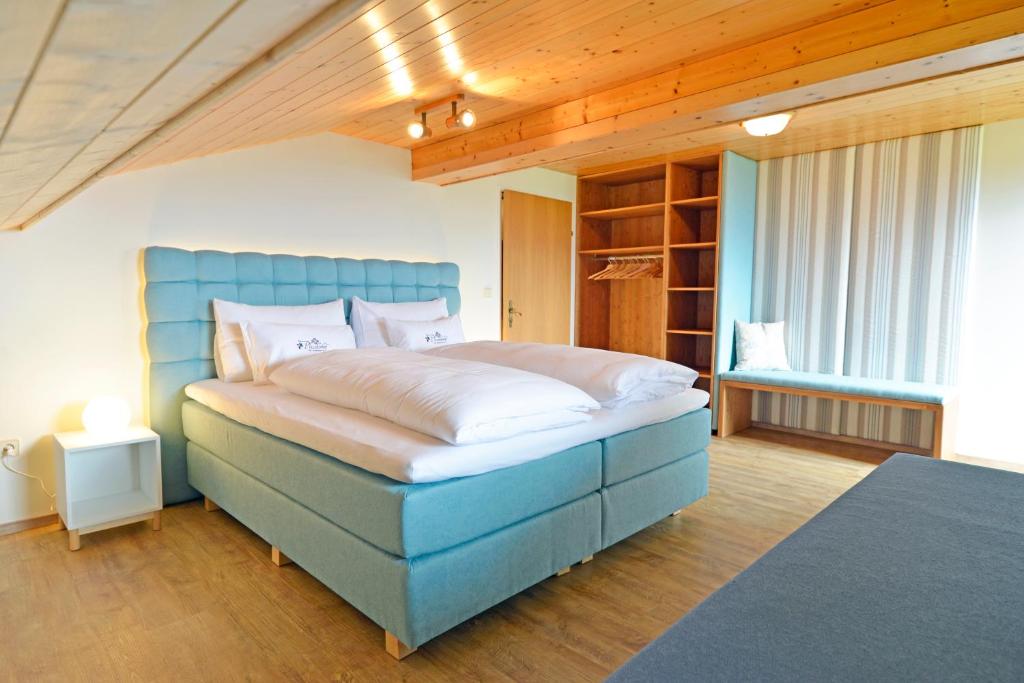 沃尔特湖畔韦尔登Pleschinhof的一间卧室配有一张大床和蓝色床头板