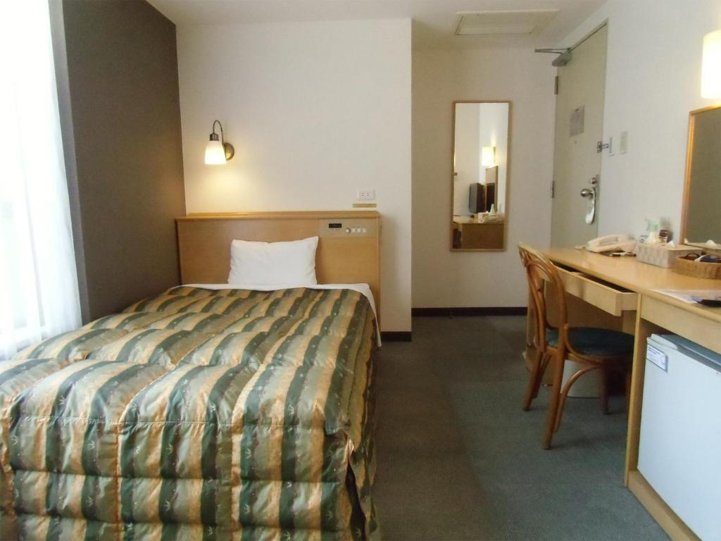 大阪Hotel Oaks Early-Bird Osaka Morinomiya/ Vacation STAY 28682的配有一张床和一张书桌的酒店客房