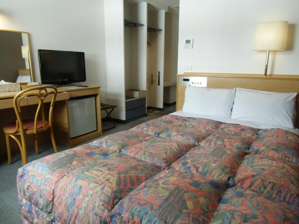 大阪Hotel Oaks Early-Bird Osaka Morinomiya/ Vacation STAY 28787的一间卧室配有一张床和一张书桌及电视