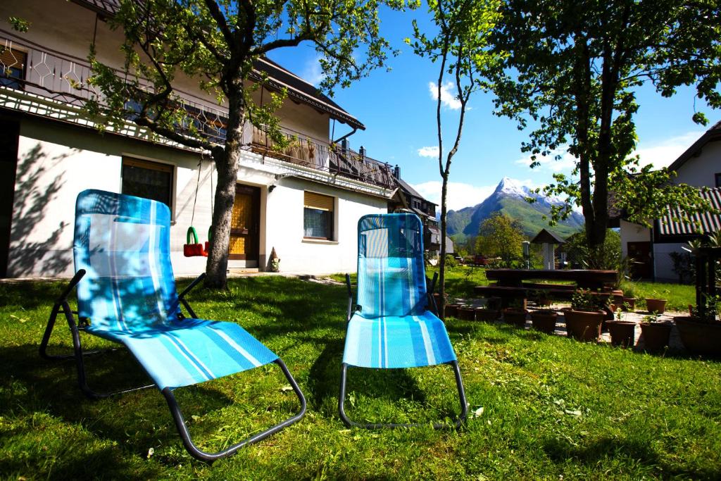 博维茨Bovec Holiday House的两把蓝色椅子坐在房子前面的草上