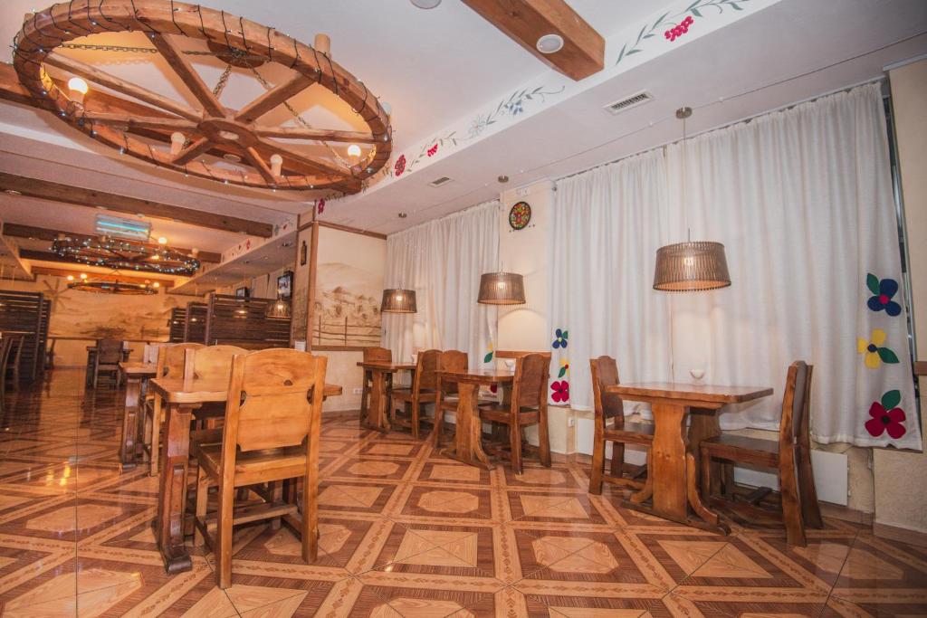 鲁斯塔维奥托帕帕酒店的餐厅设有木桌、椅子和吊灯。