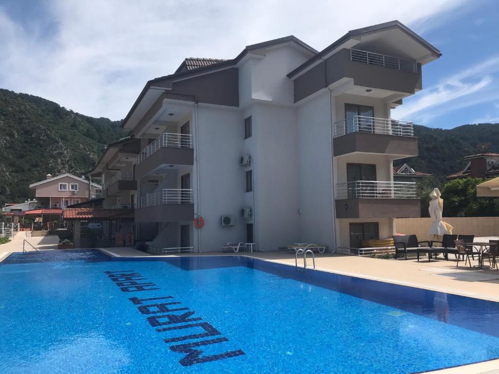 马尔马里斯Murat Apart Hotel的一座别墅,在一座建筑前设有一个游泳池