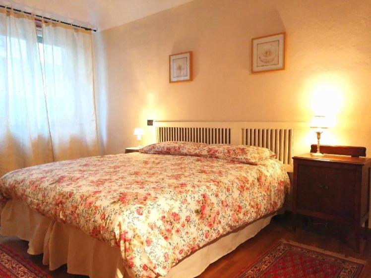 韦尔切利Pane&Burro的一间卧室配有一张带花卉床罩的床