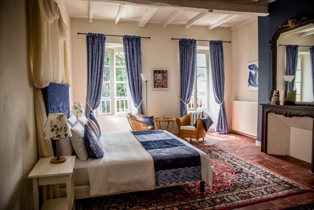 圣昂托南La Résidence Chambre d'Hotes的一间卧室配有一张特大号床和蓝色窗帘