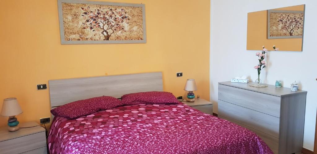 PescinaCasa Lory的一间卧室配有一张带粉红色棉被的床