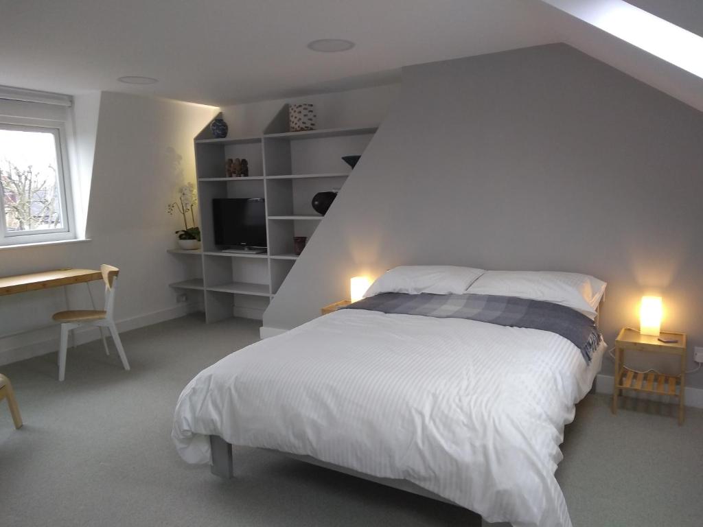 伦敦Sandra & Andrew's B&B的一间卧室配有一张床、一张书桌和一个窗户。