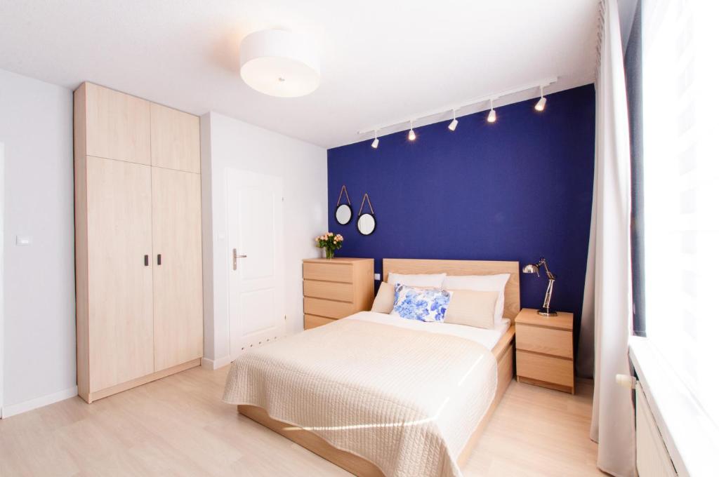 尤斯托尼莫斯基Pokoje Gościnne Abelard的一间卧室设有一张床和蓝色的墙壁