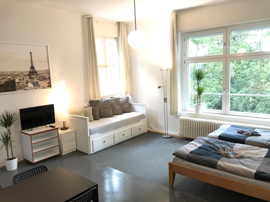 萨勒河畔哈雷Ferienwohnungen und Apartmenthaus Halle Saale - Villa Mathilda的带沙发、床和窗户的客厅