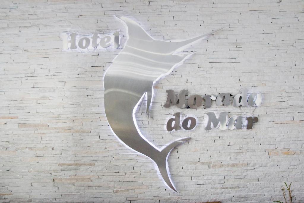 瓜鲁雅Hotel Morada do Mar的白色的墙,上面有字牌,上面写着傻瓜的字样