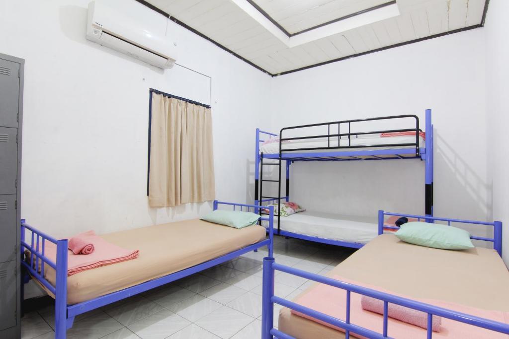 三宝垄Arjuna Hostel的客房设有两张双层床和一扇窗户。