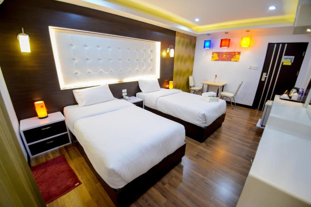 合艾โรงแรมลลิตา บูติค的酒店客房设有两张床和一张桌子。