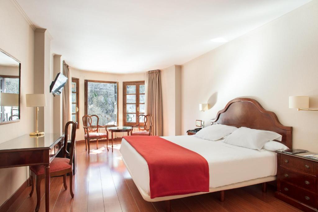 西斯伯尼阿巴夏洛特套房酒店的酒店客房带一张床铺、一张书桌和一间卧室