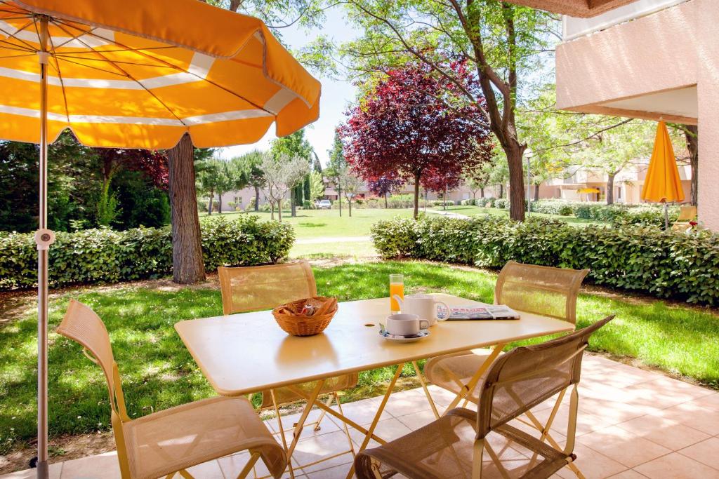 巴亚盖斯梅萨恩花园酒店的庭院里配有桌椅和遮阳伞