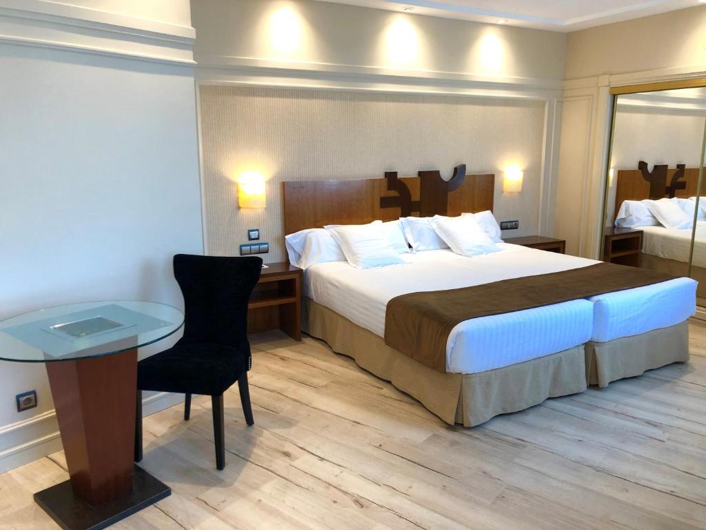 巴利亚多利德奥里德酒店的酒店客房设有一张大床和一张桌子。