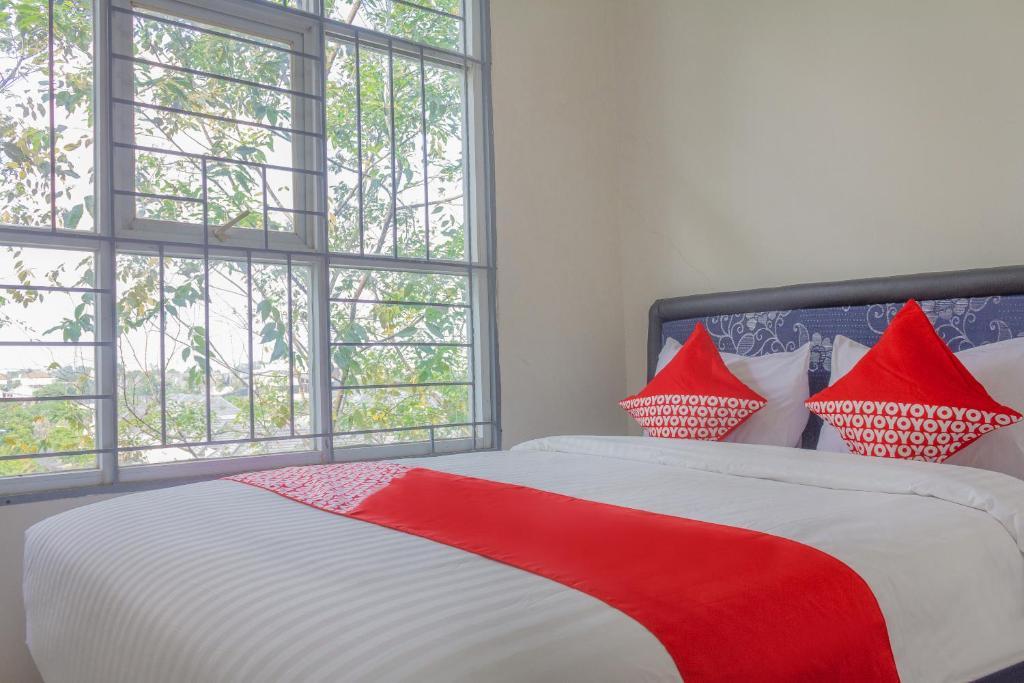 TjilandakOYO 39077 Guesthouse的卧室设有红色和白色的床和窗户。