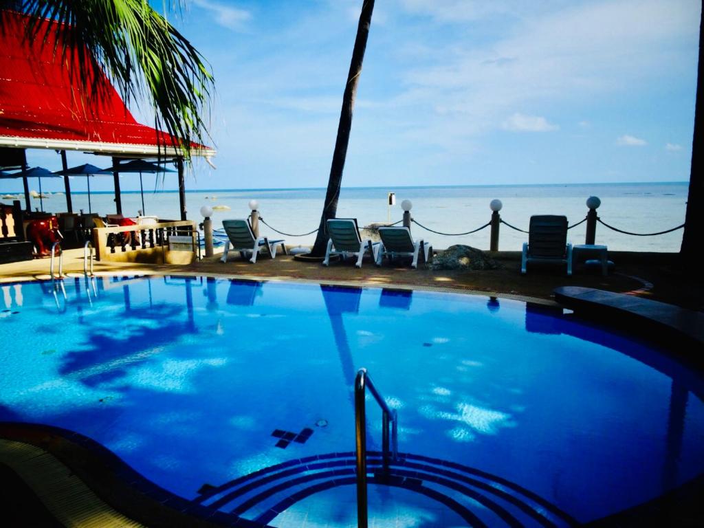 苏梅岛Starbay Samui的一个带椅子的游泳池,背景是大海