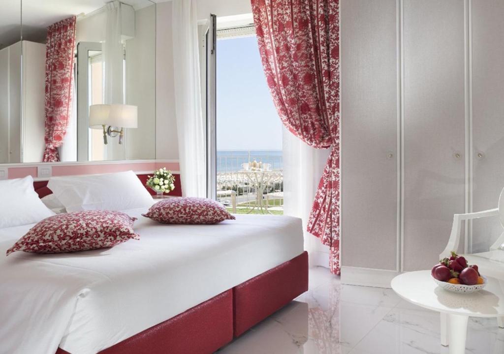 里米尼里米尼米尔顿酒店的一间卧室设有一张大床和一个大窗户