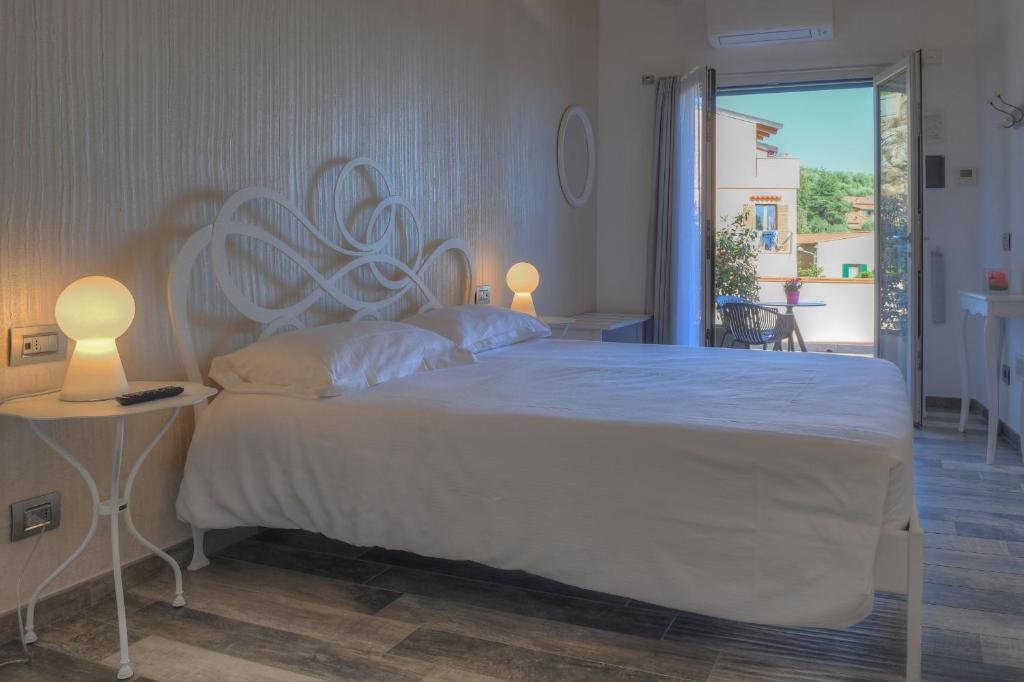 菲纳莱利古雷La Locanda di Cucco的一间卧室配有一张带两盏灯的大型白色床。