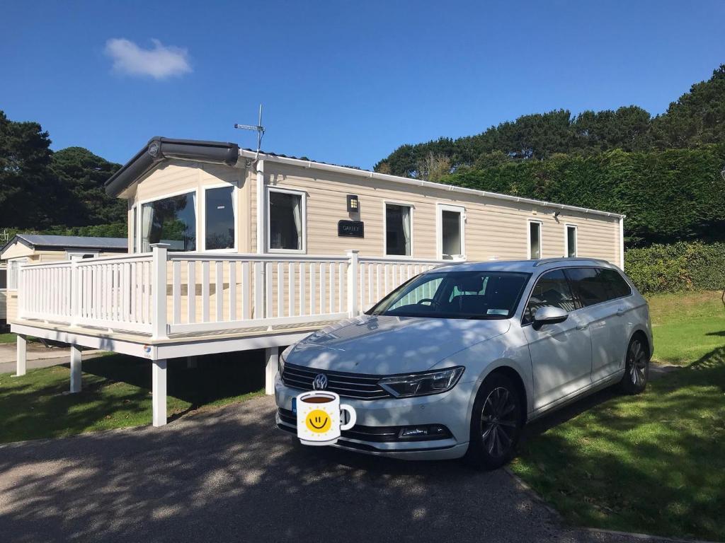 纽基Luxury Holiday Caravan Home的把车停在房子前面,喝杯咖啡