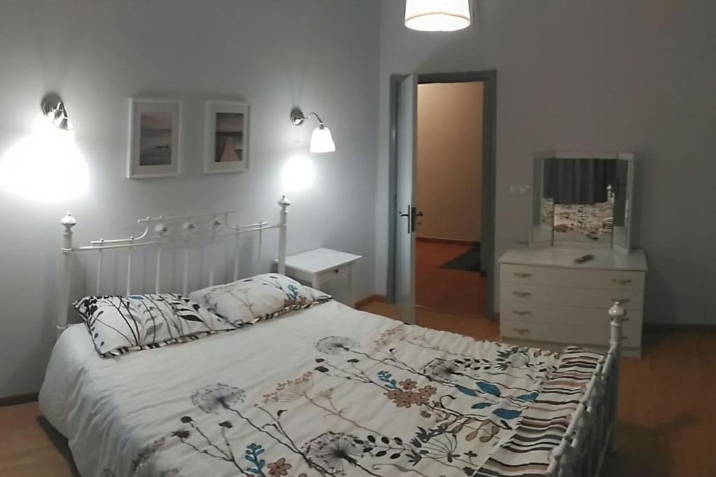 维塞乌Casa Viela的一间卧室配有一张床、梳妆台和镜子