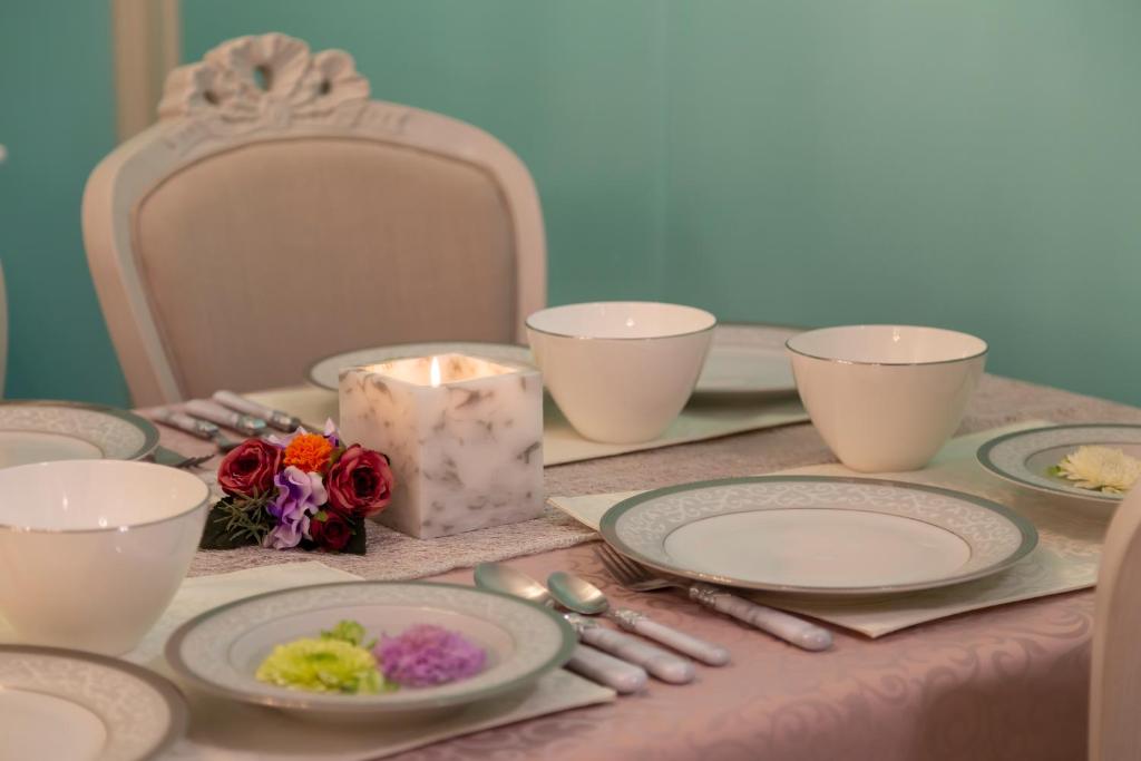 名古屋SakurA的一张桌子,上面放有盘子,蜡烛和鲜花