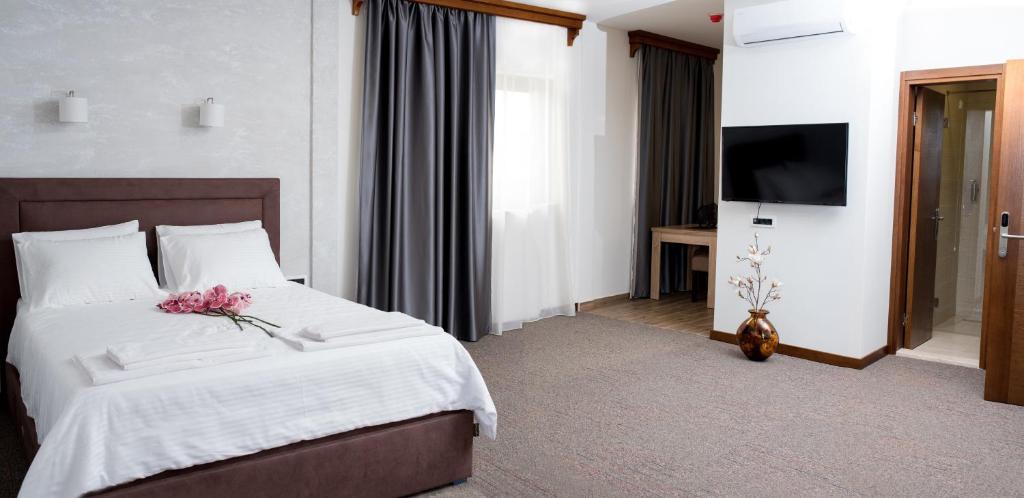 波德戈里察IPN APARTMENTs的一间卧室配有一张带白色床单的床和电视。
