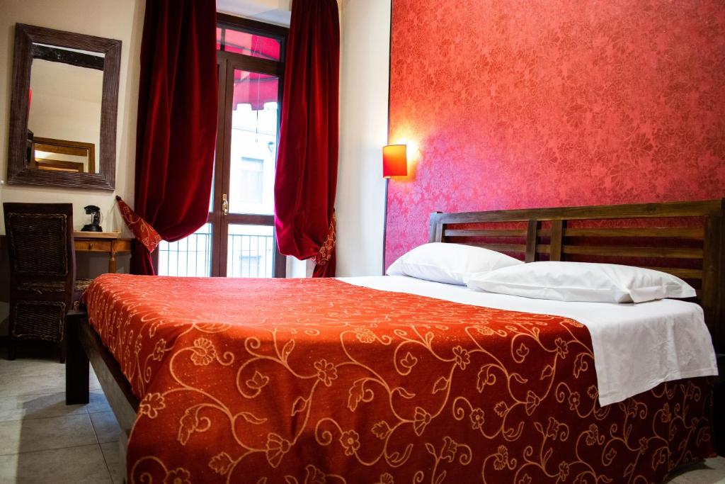 卢切拉卢切拉慕罗托尔朵旅馆的一间卧室设有一张红色墙壁和窗户的床