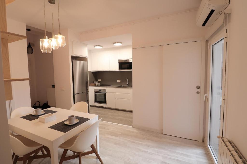 赫罗纳Cool Apartment - Parc Migdia - Center Girona的厨房以及带桌椅的用餐室。