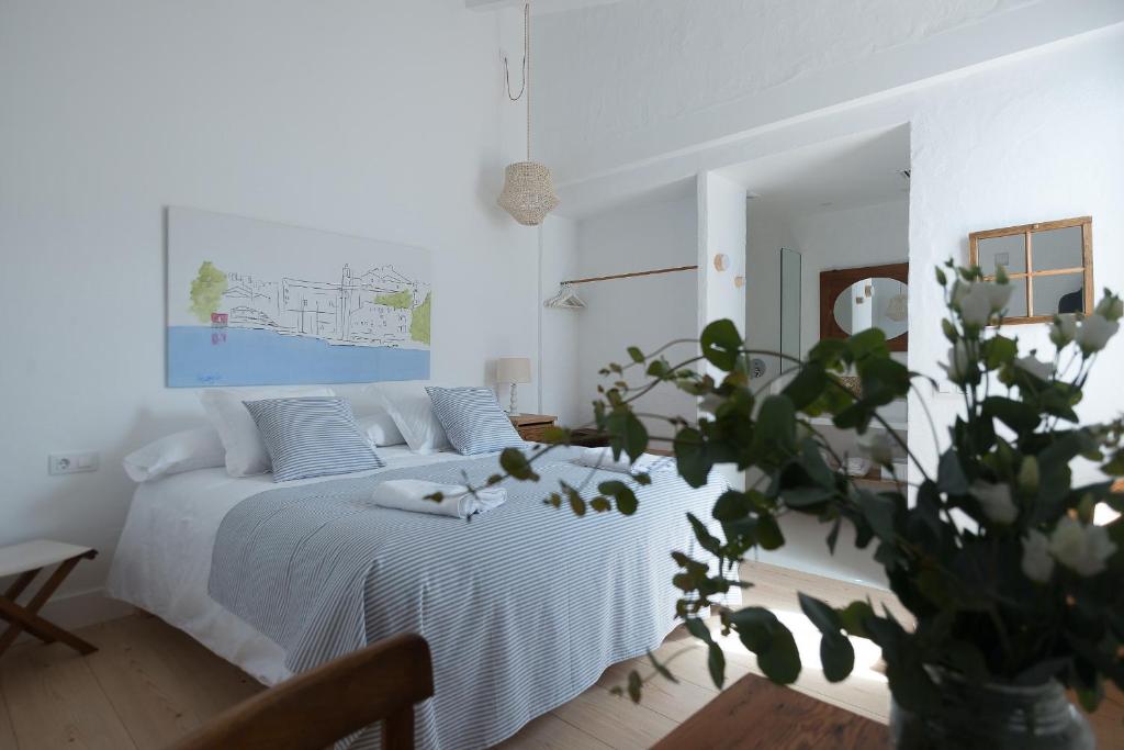 费雷列斯HOTEL ANHEL的一间白色卧室,配有床和植物