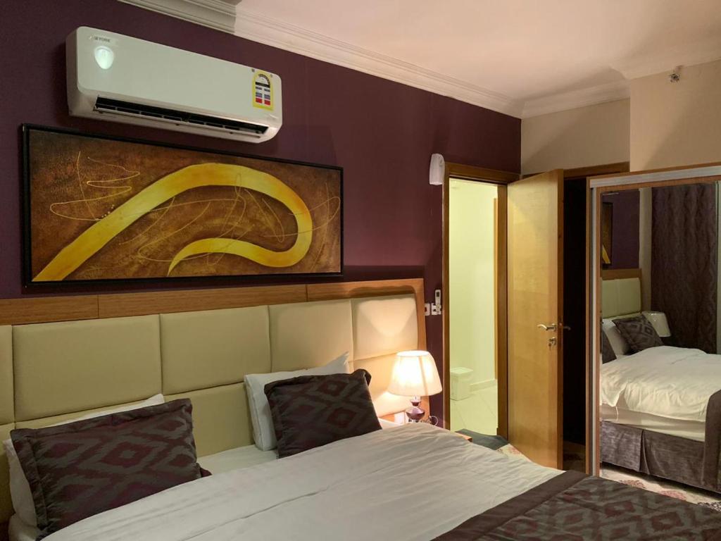 麦加Altelal Apartment的酒店客房设有一张床和墙上的电视