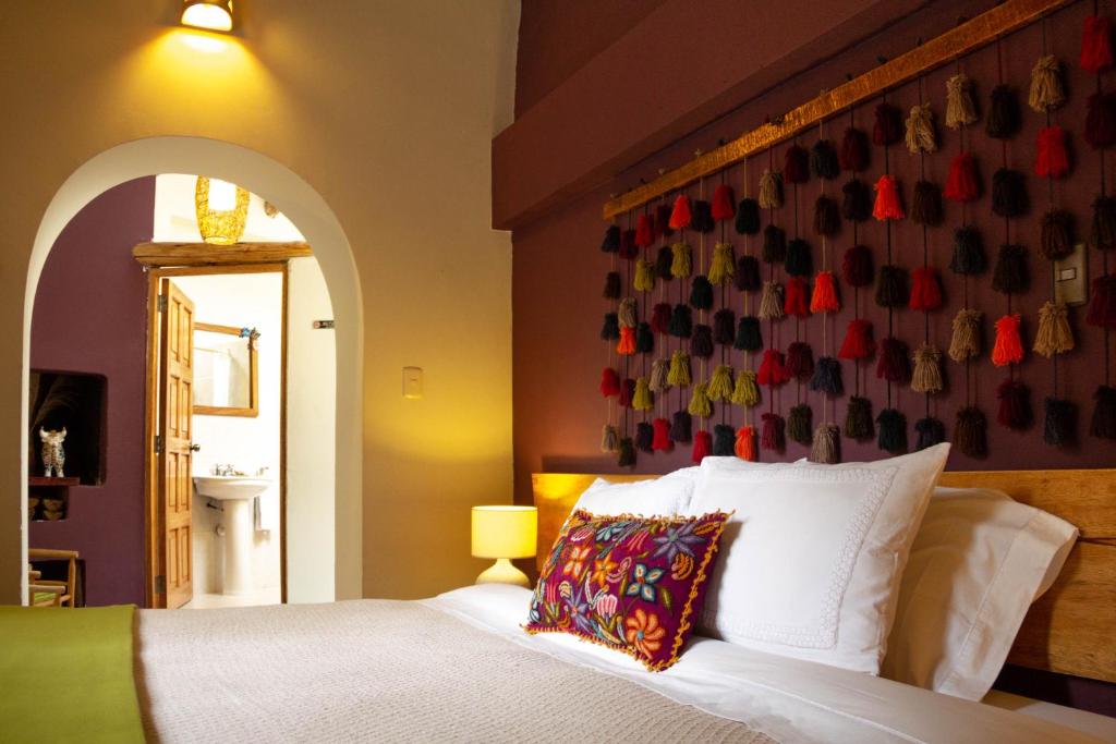 奥兰太坦波Casa de La Chola的一间卧室配有床和一堵带鞋的墙