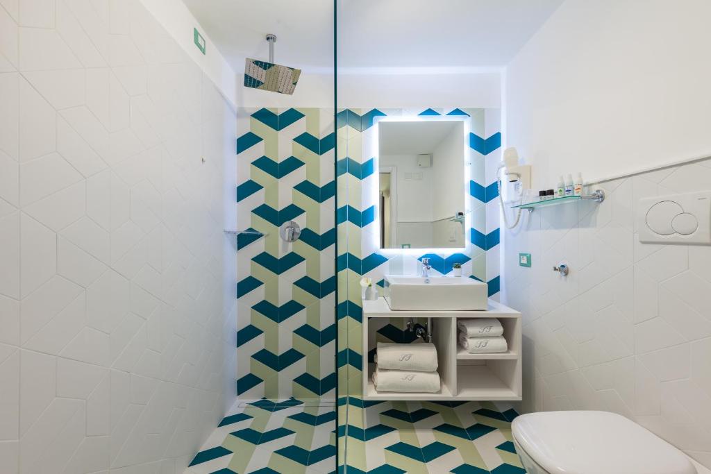 索伦托索伦托费拉特斯酒店的一间带卫生间、水槽和镜子的浴室