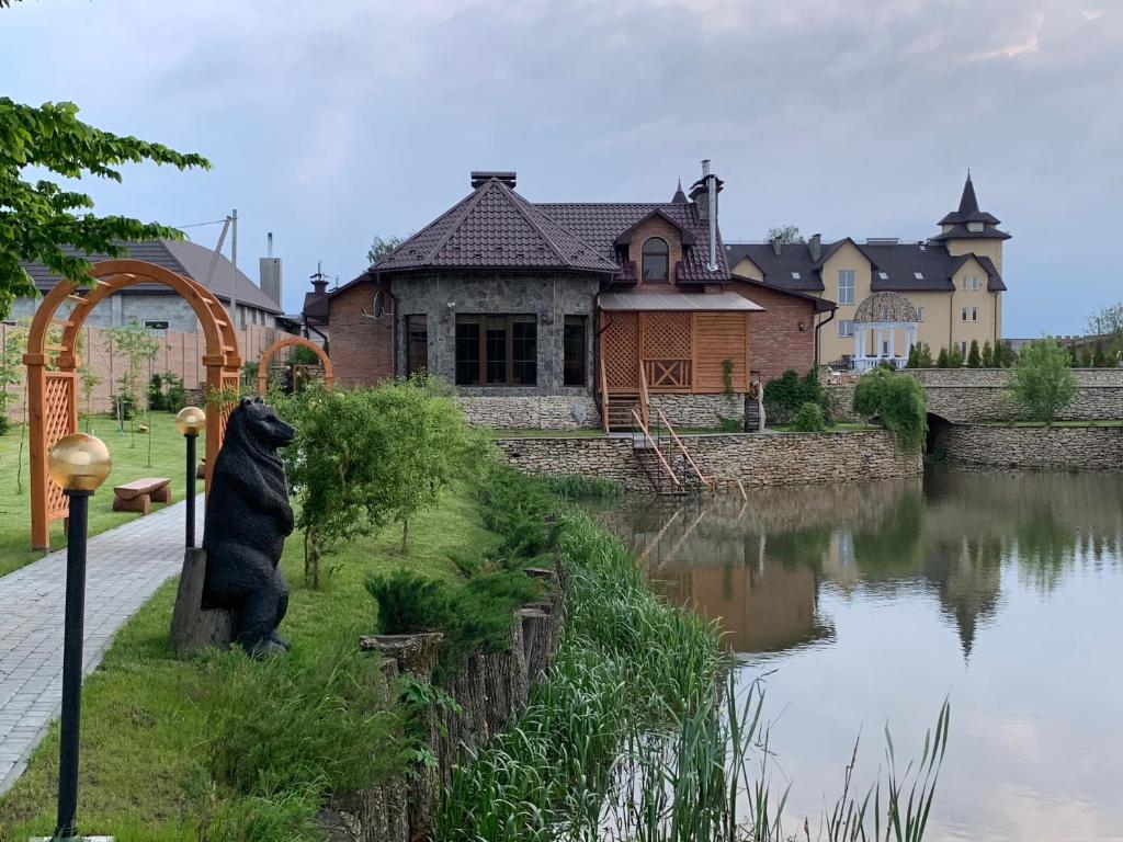 波恰耶夫Готельно-ресторанний комплекс Прованс парк的坐在河边的熊雕像