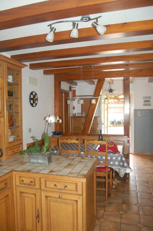 ObersaasheimLe gîte à l'ombre du tilleul的一个带木制橱柜和桌子的厨房