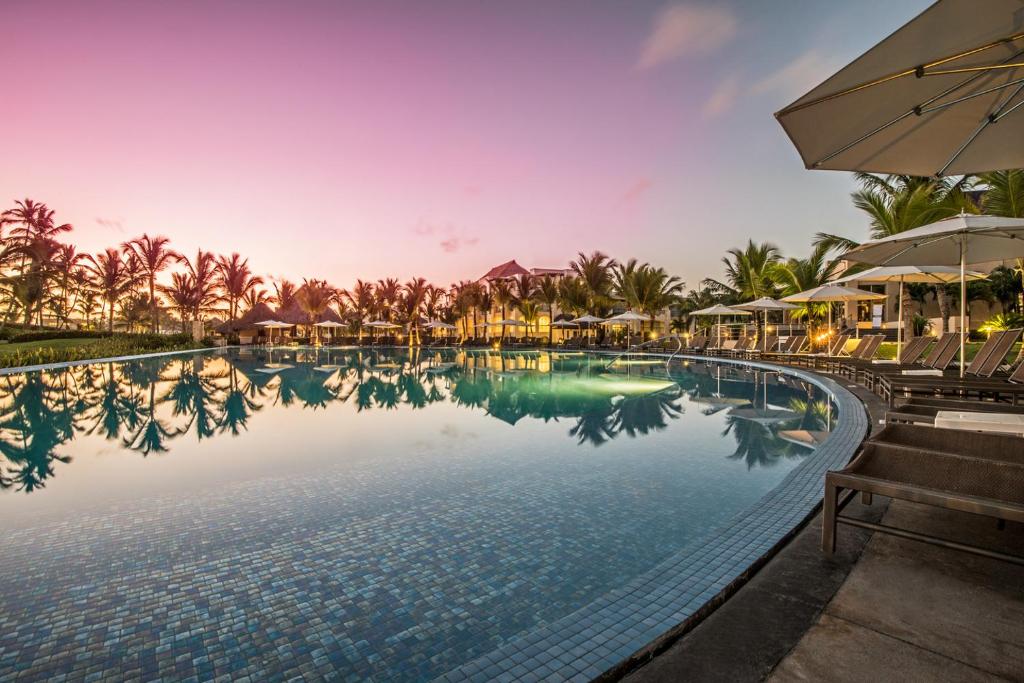 蓬塔卡纳Hard Rock Hotel & Casino Punta Cana - All Inclusive的一个带遮阳伞的度假村游泳池
