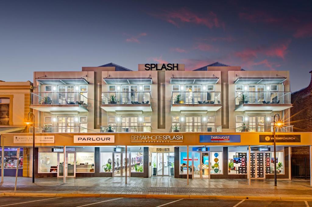 Port Adelaide塞玛佛尔水滨公寓的一座大型建筑,前方是商店