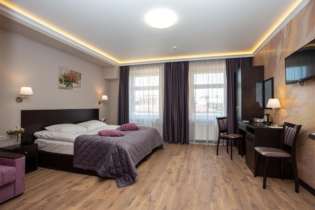 圣彼得堡Margarita Hotel的配有一张床和一张书桌的酒店客房