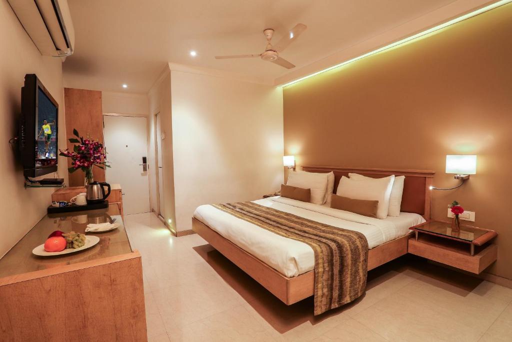 孟买Hotel Suncity Apollo, Colaba的酒店客房设有一张大床和一台电视。