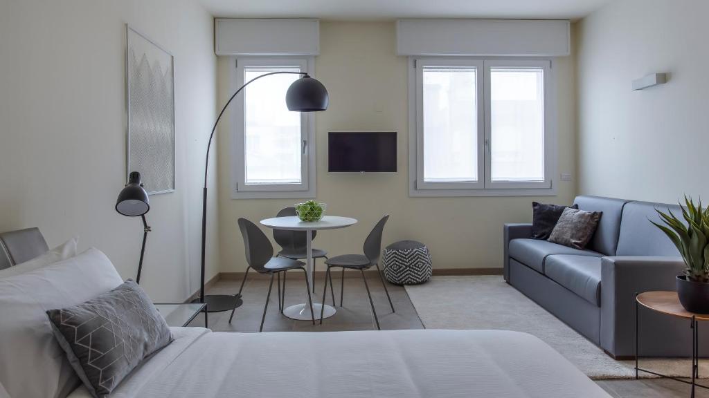 帕多瓦Erïk Langer Pedrocchi Suites的客厅配有沙发和桌子