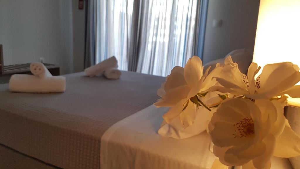 雷夫卡达镇CELENI APARTMENTS的一张带两条毛巾和鲜花的床