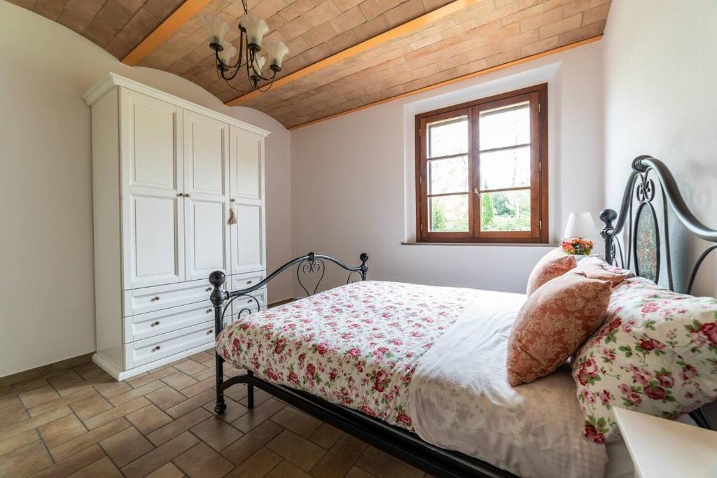 切塔尔多Appartamento nella Campagna di Certaldo Il Ciliegio的一间卧室配有一张床、一个梳妆台和一扇窗户。