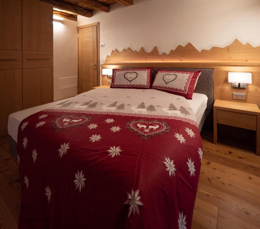 瓦尔迪佐多Stella Alpina Suite的一间卧室配有一张带红白毯子的床