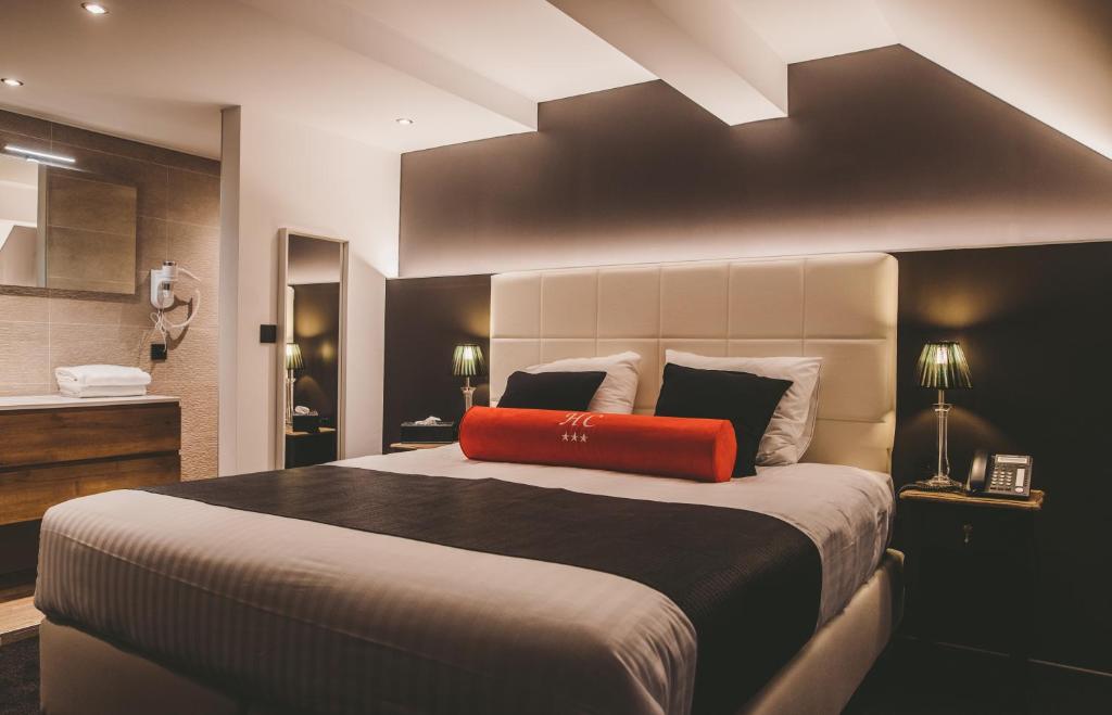 列日Hôtel Hors-Château - Liège Centre Historique的一间卧室配有一张大床,上面有红色枕头