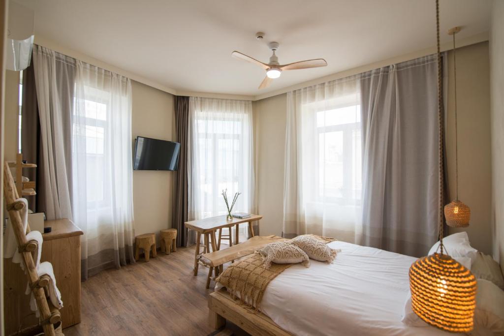 雅典Ederlezi Boutique Hotel的卧室配有一张床、一张书桌和窗户。