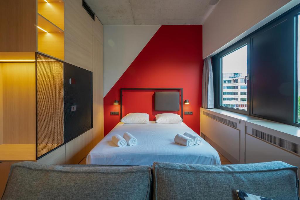 阿姆斯特丹Via Suites的一间卧室设有一张床和红色的墙壁