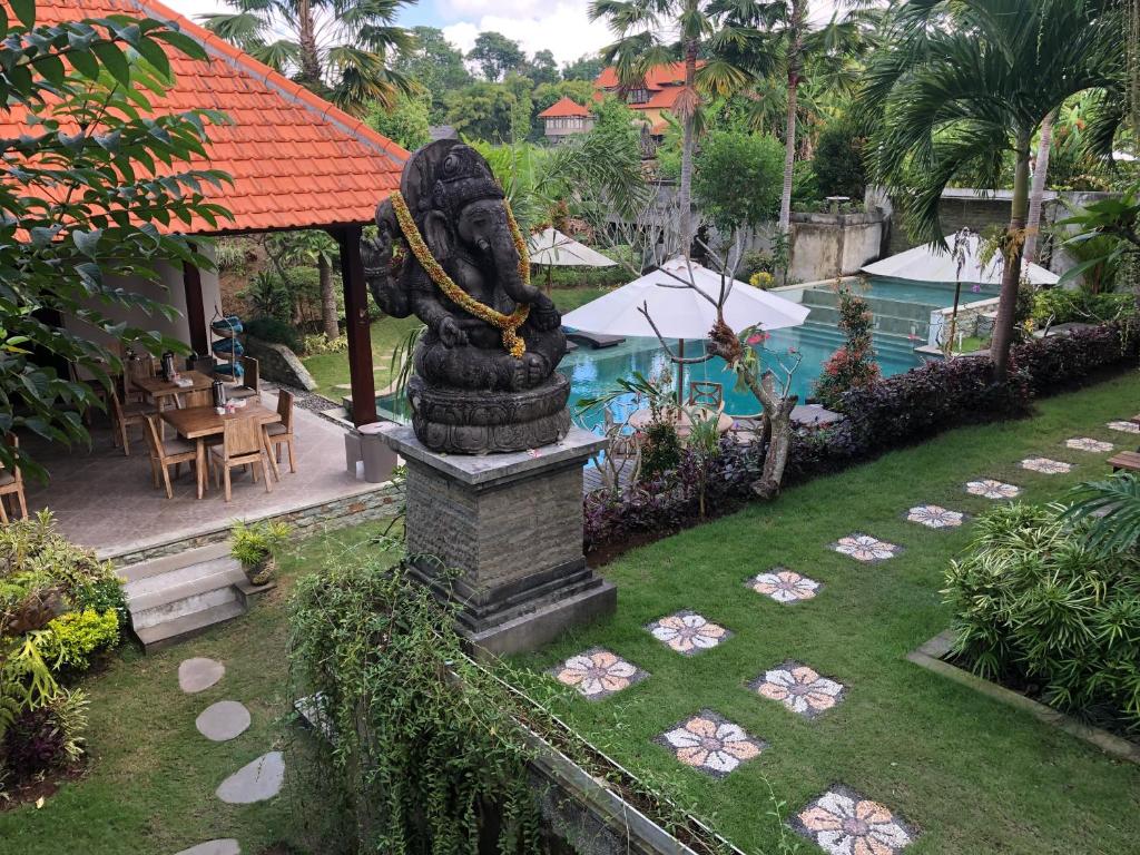 乌布巴厘岛贝图图别墅旅馆的一座带游泳池的度假村庭院内的雕像