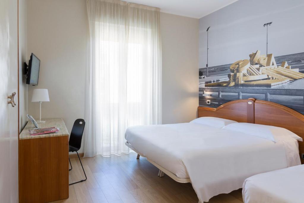 佩斯卡拉佩斯卡拉住宿加早餐酒店的酒店客房配有两张床和一张桌子及椅子